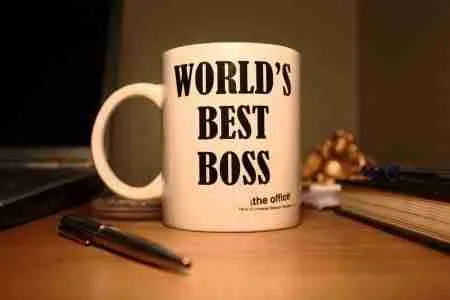 A mug with the inscription "world's best boss" from the television show "the office" on a desk with a pen and notebook, suggesting a workspace with a touch of humor. best secured loans