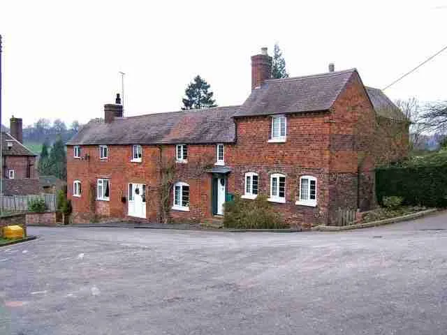 Traditional red brick country house with multiple chimneys, reflecting a classic rural architectural style. homeowner loans direct lenders
