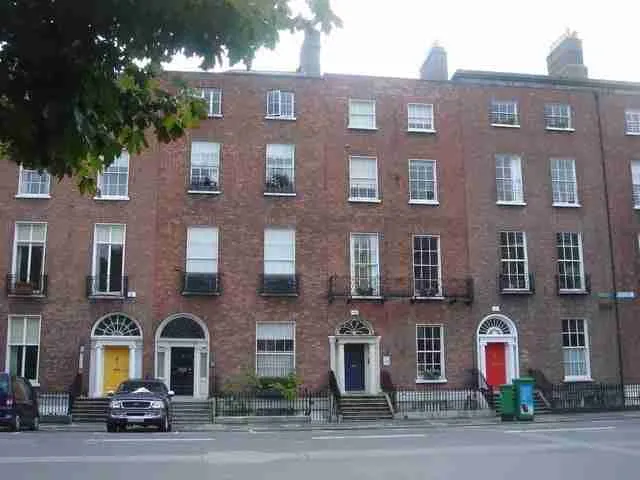 Classic red-brick georgian townhouses with colorful doors lining a serene street. uk homeowner loans