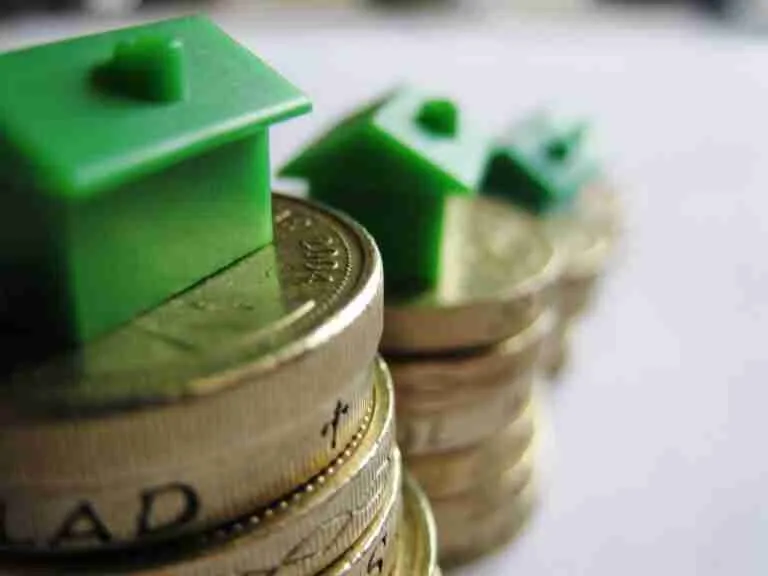 A row of increasing stacks of coins with miniature houses on top, symbolizing real estate investment, property value growth, or savings for home buying.
