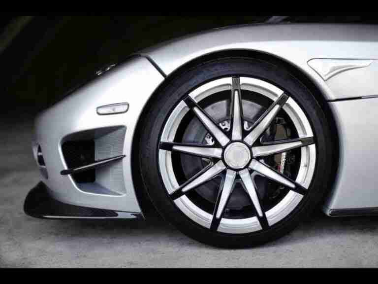 Close-up of a silver sports car's front wheel and aerodynamic vent detail. car finance
