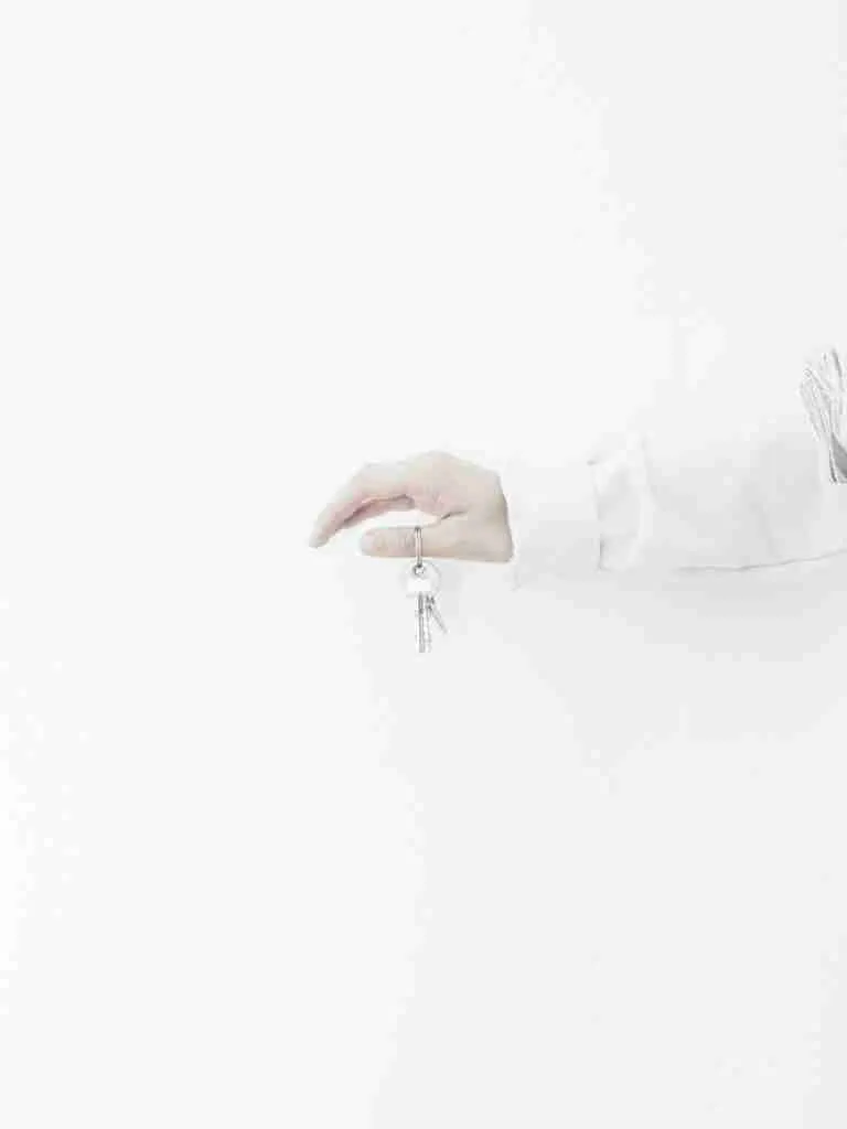 Hand holding keys against a white background. new homeowner loans bad credit