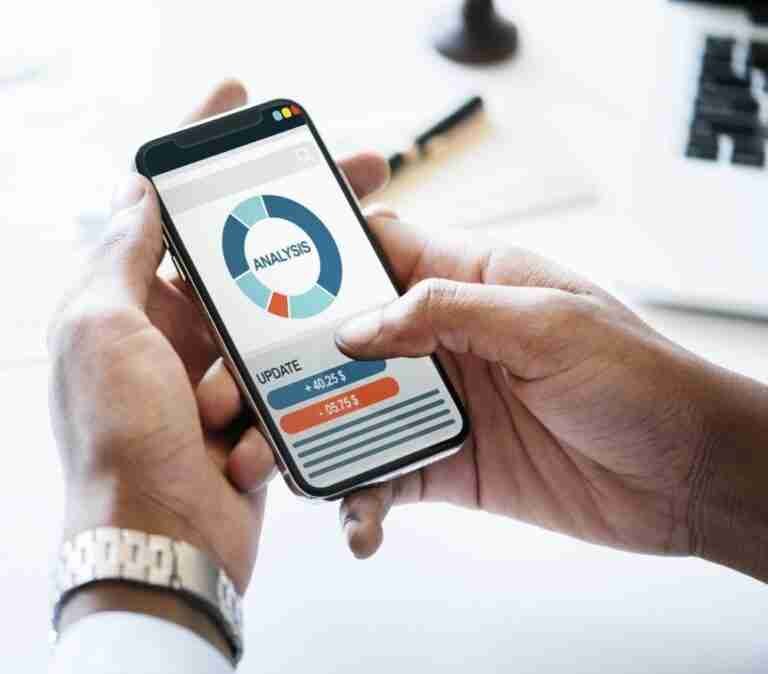 Business professional analyzing real-time data through a mobile analytics app on a smartphone.