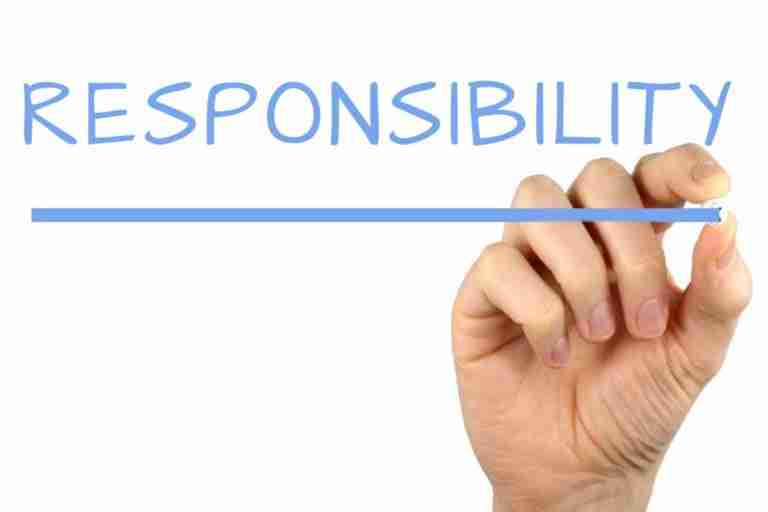 A hand holding a marker and underlining the words "responsible lending" written in blue capital letters on a white background.