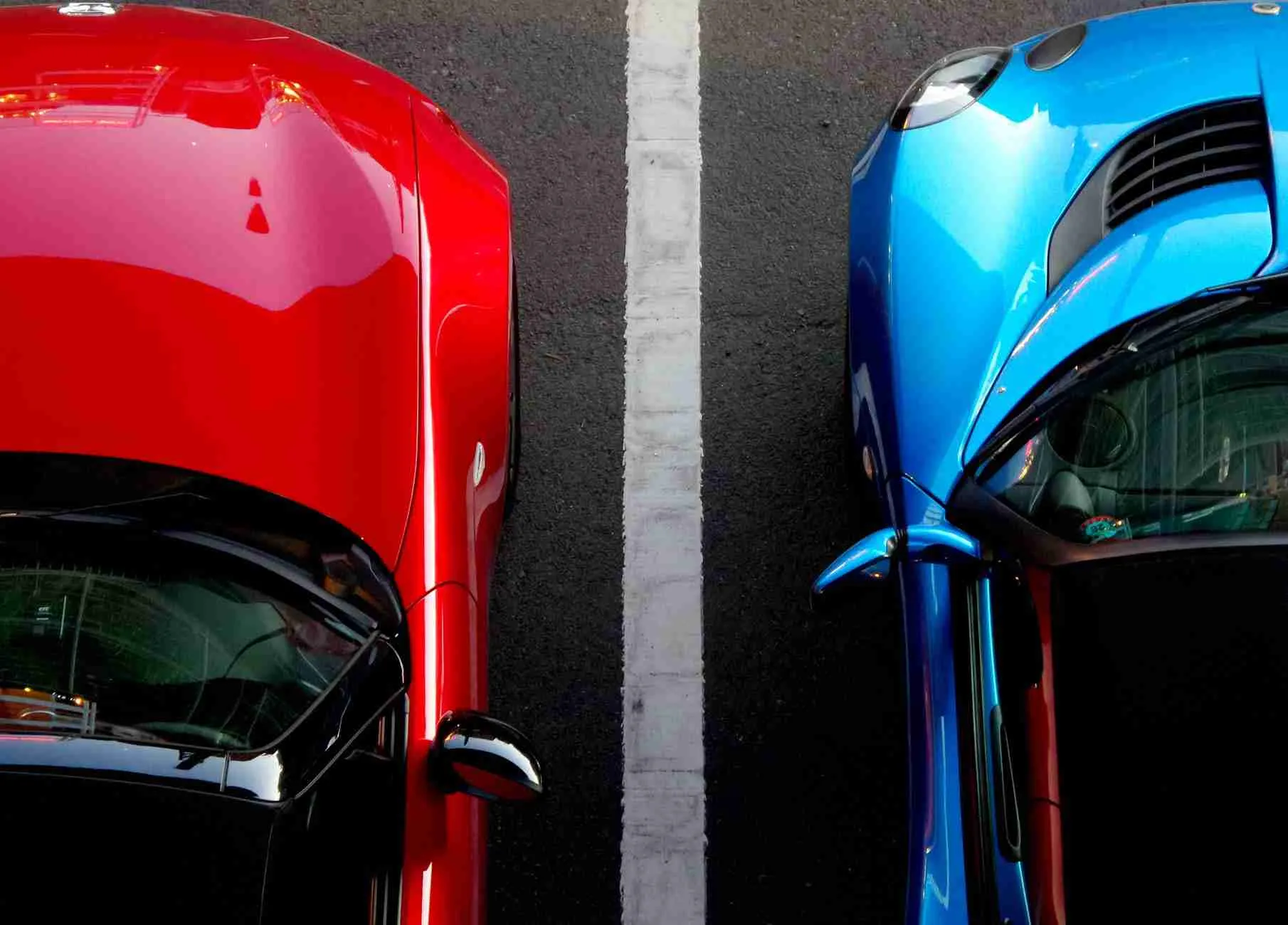 Red meets blue: a vibrant contrast of colorful cars parked side by side. Car Loans 4 U