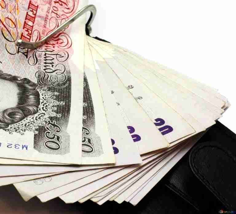 A fan of british currency notes arranged in a spread, with the focus on the £50 note, against a white background.