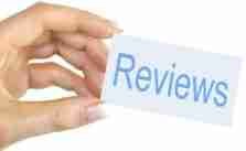 A hand holding a card with the word "reviews" written on it.