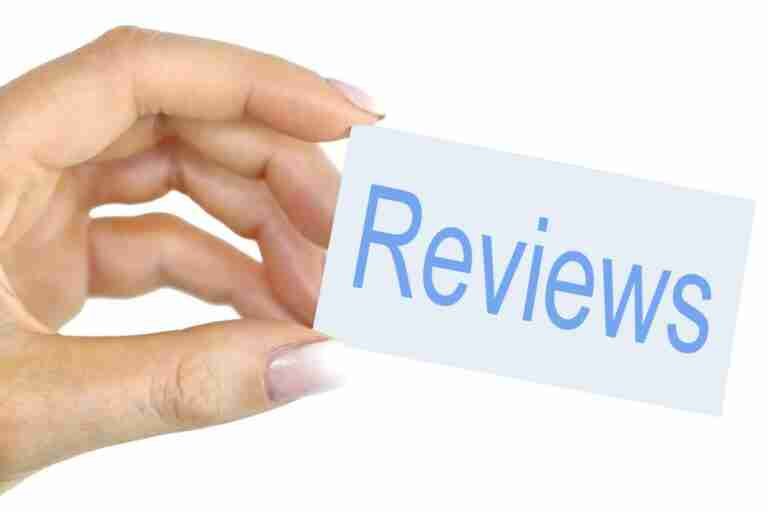 A hand holding a card with the word "reviews" written on it.