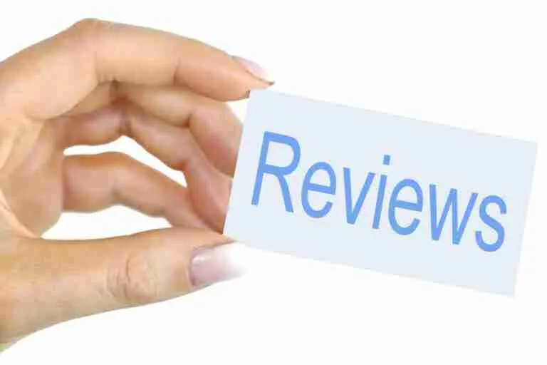 A hand holding a card with the word "reviews" written on it.