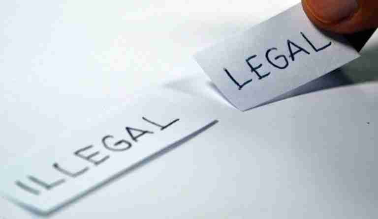 Changing the narrative: a hand flipping a paper strip from 'illegal' to 'legal'. how to find a loan shark who is legitimate