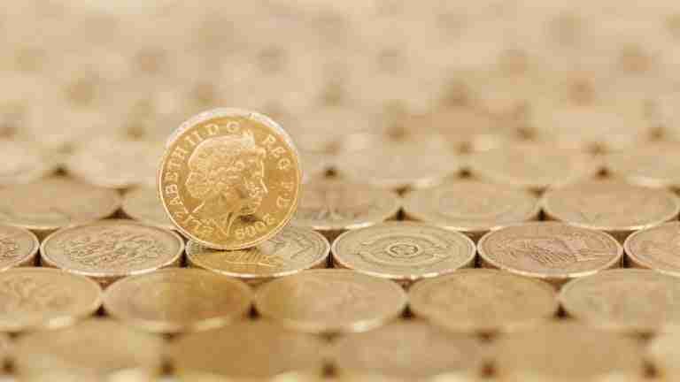 One coin standing tall amidst a field of lying coins, showcasing uniqueness and standing out from the crowd.