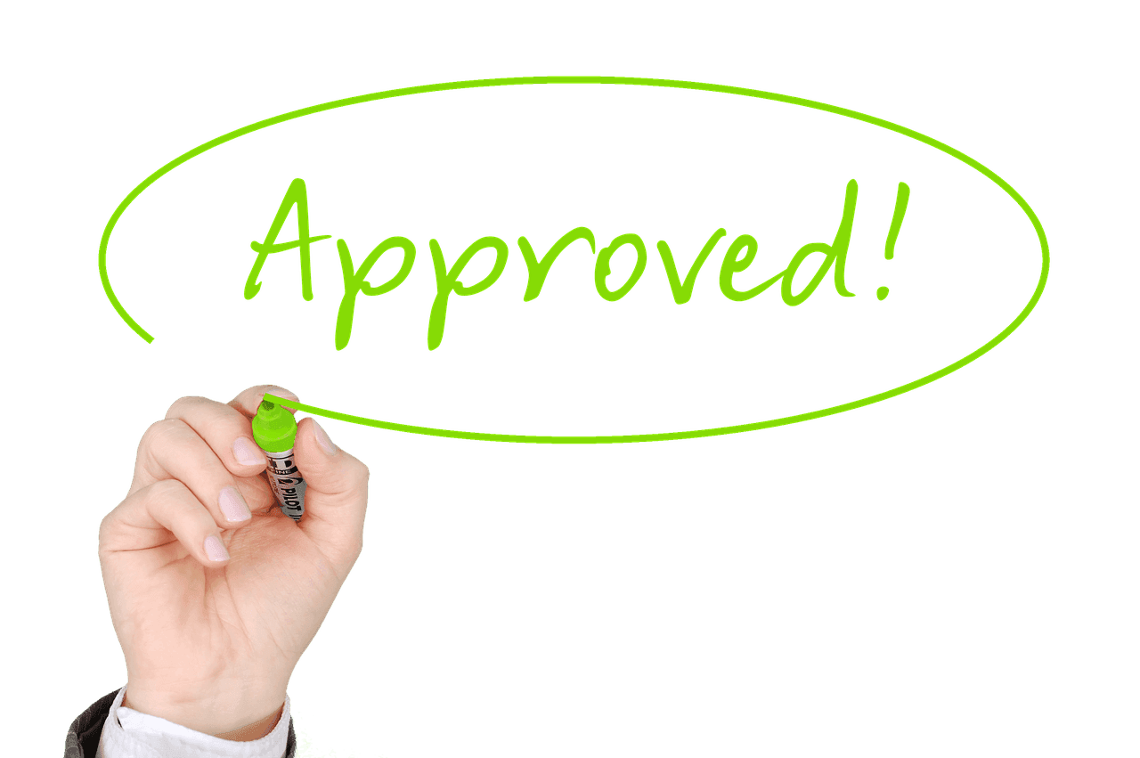 A hand holding a marker having just written the word "approved!" encircled with a vibrant green line on a transparent background.