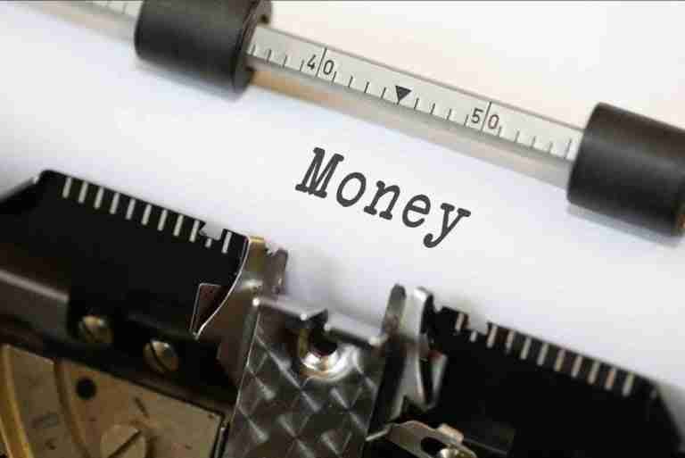 Typing out finances: vintage typewriter with the word 'money' prominently centered on the page.