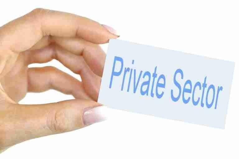 A hand holding a card with the words "private sector" printed on it, symbolizing a concept or discussion related to business or non-governmental organizations.
