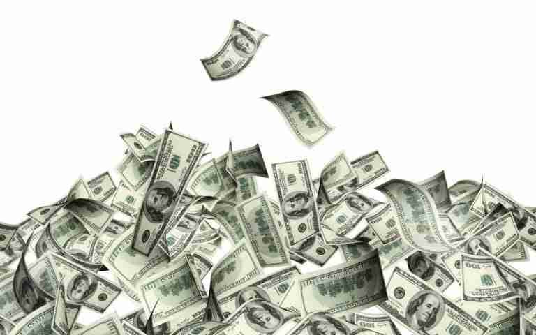 An avalanche of us dollar bills against a white background, symbolizing wealth, financial success, or possibly a windfall.