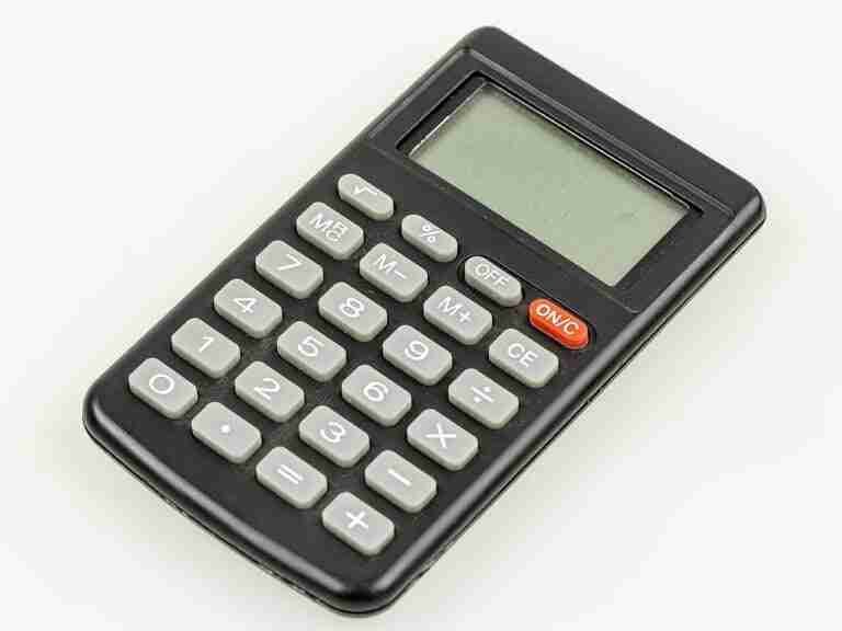 A basic electronic calculator with a black body and white buttons, featuring an lcd display, placed on a white background. car calculator calculator for car loan
