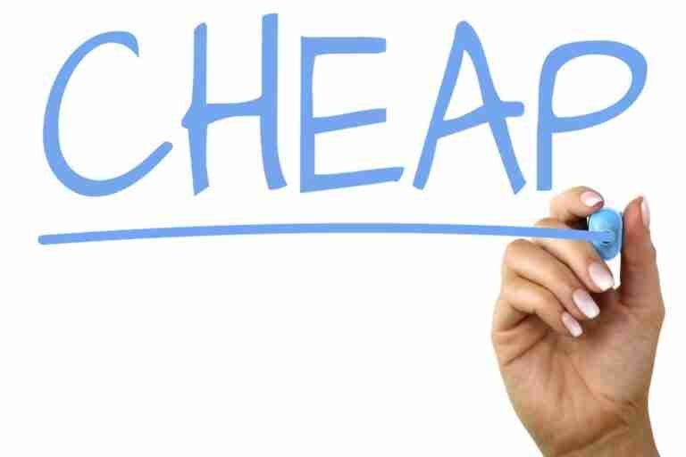 A hand with a blue marker finishing the letter 'P' in the word "CHEAP," which is written in a large blue font on a white background.
