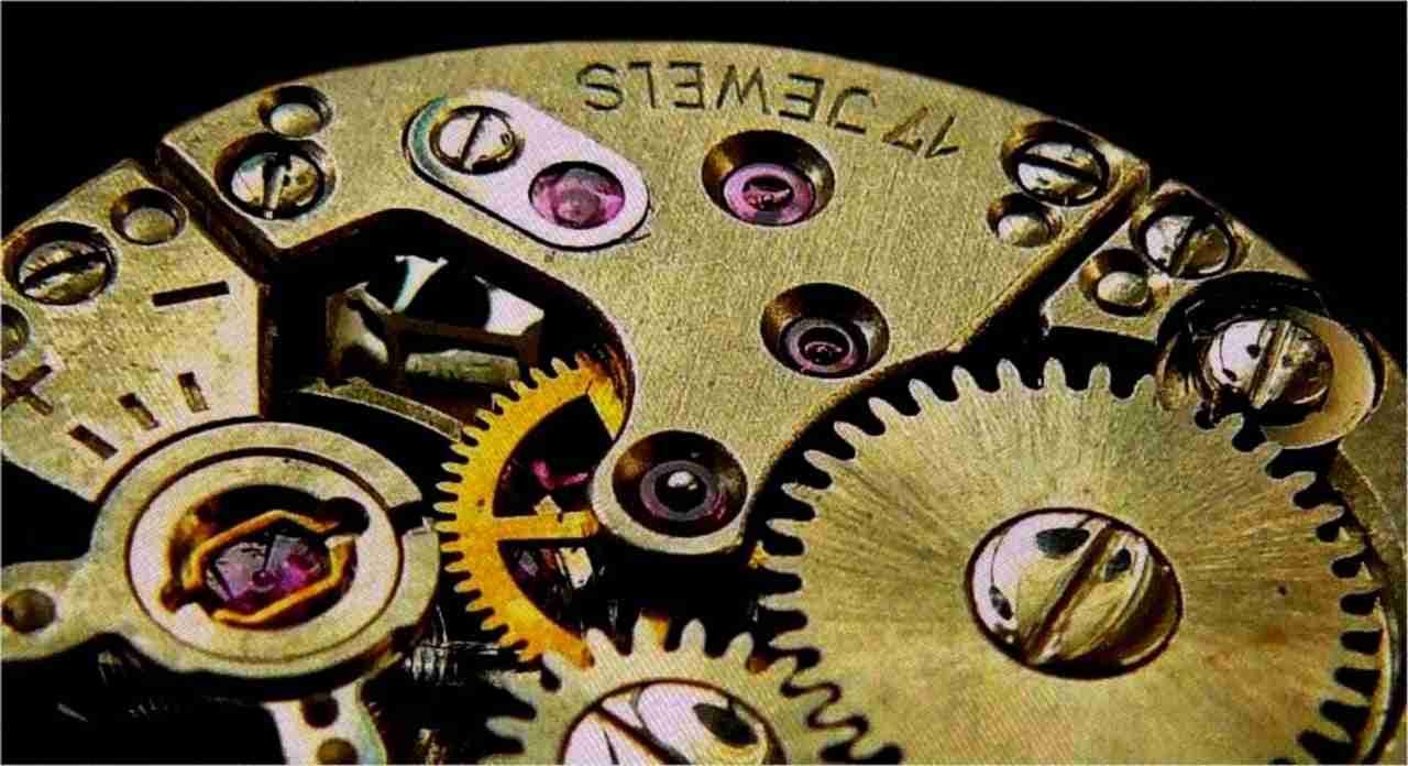 A close-up of the intricate details of a mechanical watch movement showing gears, jewels, and engraved text. no guarantor