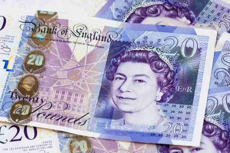 A collection of British 20 pound notes spread out, with the portrait of Queen Elizabeth II visible. affordable loans bad credit pound loan