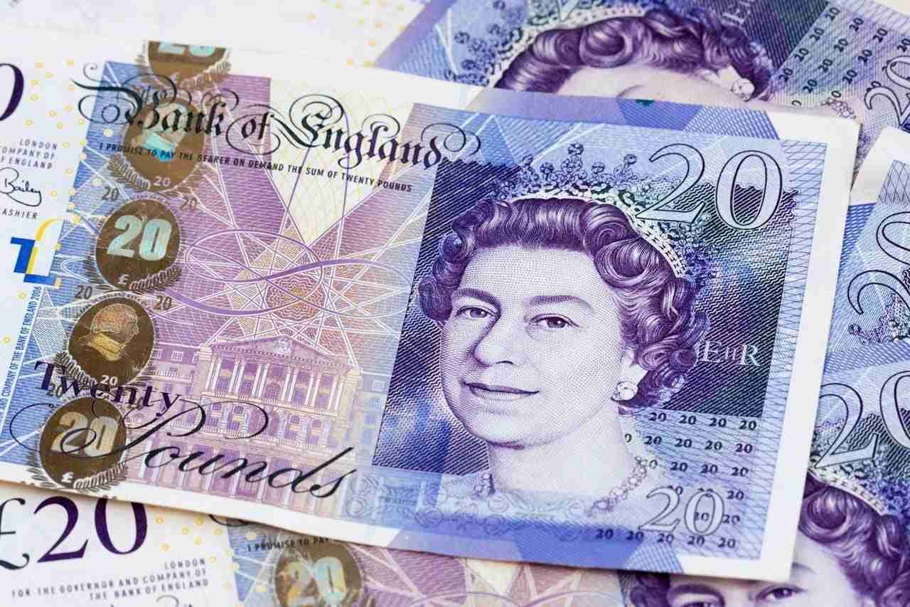 A collection of British 20 pound notes spread out, with the portrait of Queen Elizabeth II visible. affordable loans bad credit pound loan