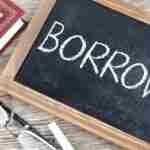 Borrow Money A chalkboard with the word "BORROW" written on it, accompanied by a pair of glasses, a white chalk piece, and a closed book with a pen on top, all resting on a wooden surface. borrow money online