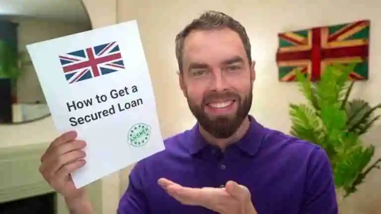 A smiling man holding a paper titled "How to Get a Secured Loan" with a British flag on it, in a room with a colorful Union Jack artwork on the wall and a potted plant on the side. what documents do I need for a secured loan
