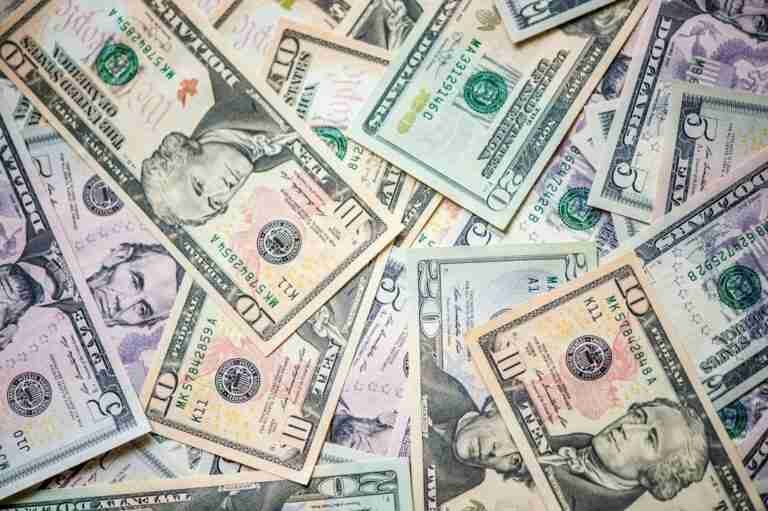 Various denominations of US currency bills scattered untidily.