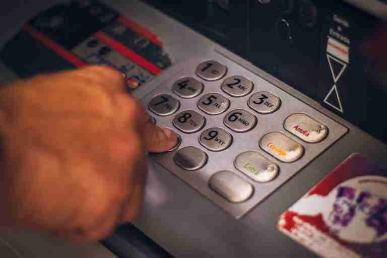A person's hand pressing a button on an ATM keypad. £1000 Bad Credit Loans
