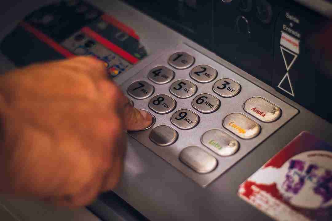 A person's hand pressing a button on an ATM keypad. £1000 Bad Credit Loans