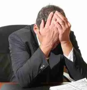 professional man with head in hands at desk