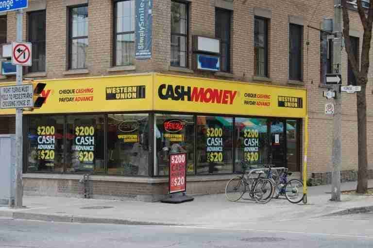 A street-level view of an "every day loans" store, which offers financial services, with a bold yellow storefront situated on a city street corner.