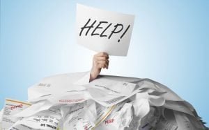 man covered in bills holding debt help sign