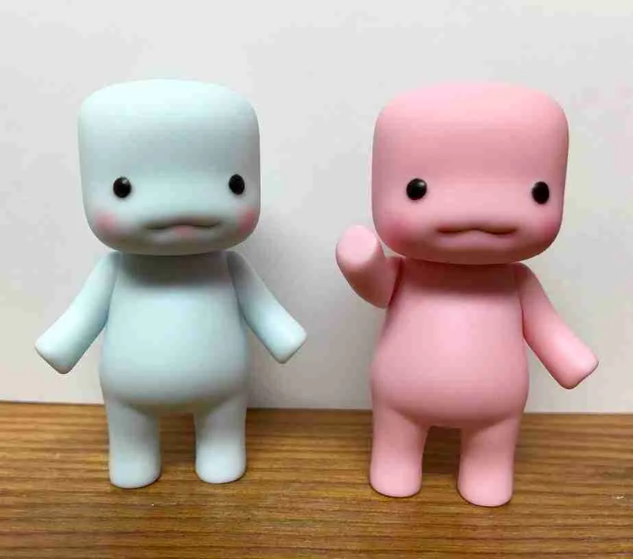 Two small, minimalist figurines representing loans with guarantors, with a humanoid shape, one in white and the other in pink, standing side by side on a neutral background.