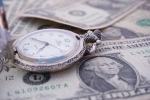 pocket watch on top of cash notes