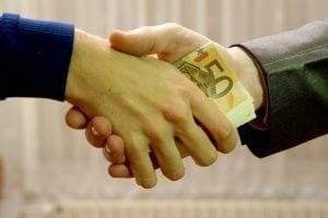 most accepted loan company handshake with cash notes in between